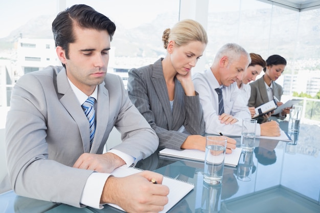 Equipo de negocios tomando notas durante la conferencia