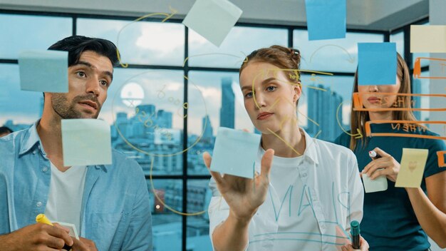 Foto equipo de negocios tormenta de ideas mientras el líder escribe en notas adhesivas tracery