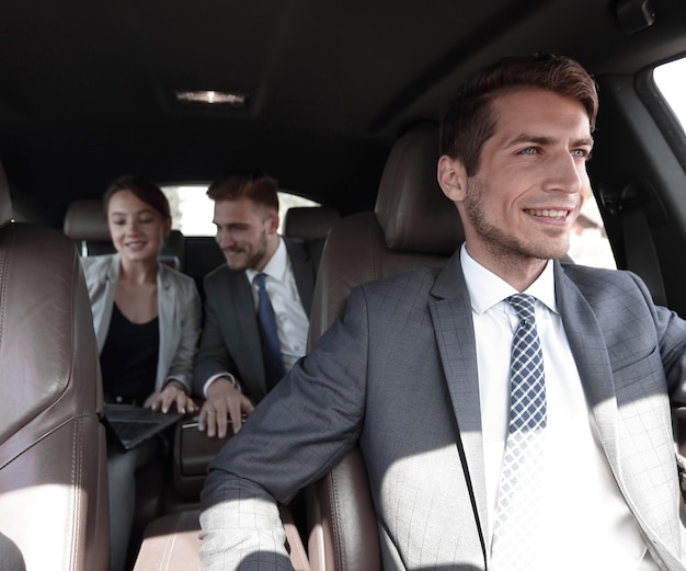 Foto equipo de negocios trabajando en el asiento trasero del auto