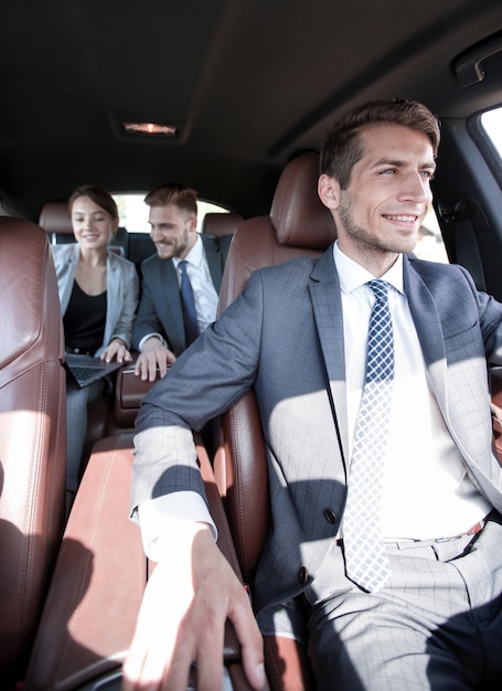 Equipo de negocios trabajando en el asiento trasero de la gente del automóvil y la tecnología.