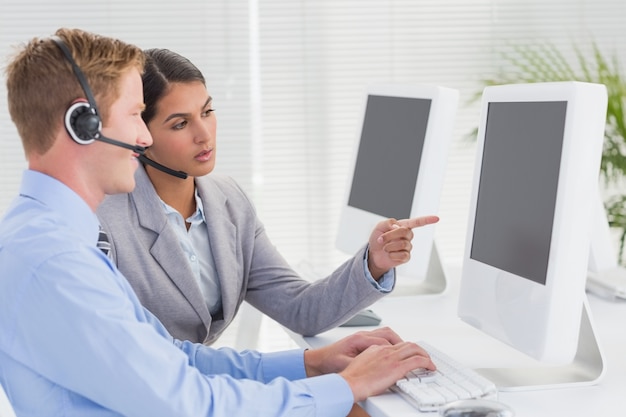 Equipo de negocios trabajando en computadoras y usando auriculares