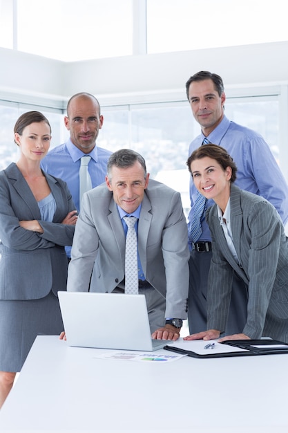 Equipo de negocios trabajando felizmente juntos en la computadora portátil