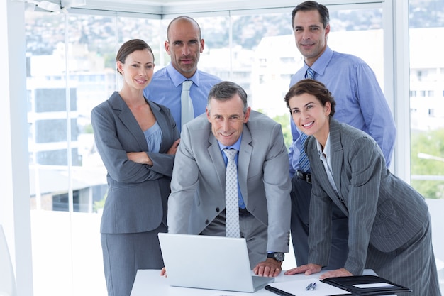 Equipo de negocios trabajando felizmente juntos en la computadora portátil