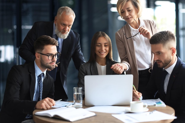 Equipo de negocios trabajando en una laptop para verificar los resultados de su trabajo.