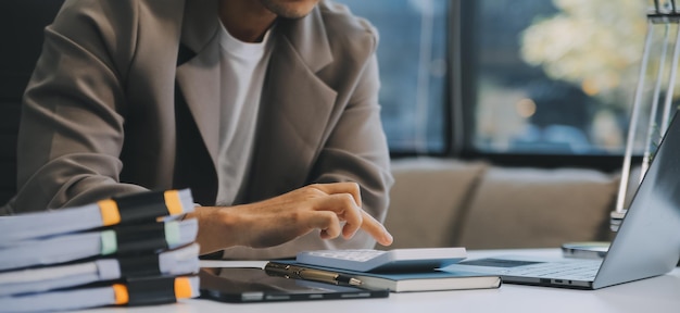 Equipo de negocios trabajando con un nuevo plan de proyecto de inicio y discusión de información para la estrategia financiera con portátil y tableta digital en una sala de negocios moderna