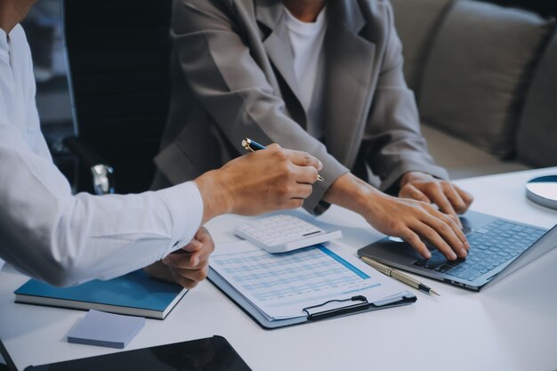 Equipo de negocios trabajando con un nuevo plan de proyecto de inicio y discusión de información para la estrategia financiera con portátil y tableta digital en una sala de negocios moderna