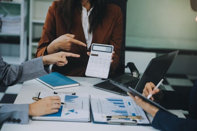 Foto equipo de negocios trabajando con un nuevo plan de proyecto de inicio y discusión de información para la estrategia financiera con portátil y tableta digital en una sala de negocios moderna