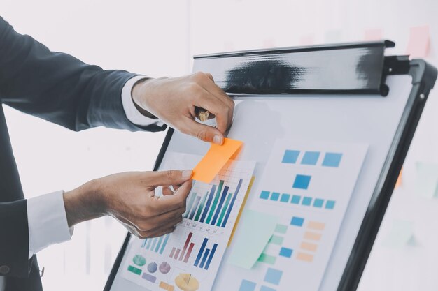 Equipo de negocios trabajando con un nuevo plan de proyecto de inicio y información de discusión para la estrategia financiera con computadora portátil y tableta digital en un salón de negocios moderno