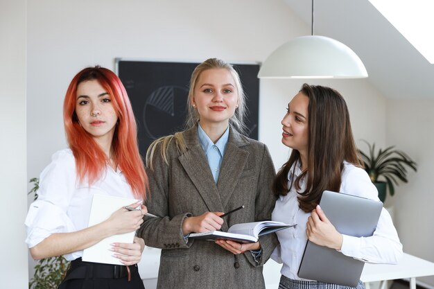 Equipo de negocios de tres mujeres jóvenes en la oficina.