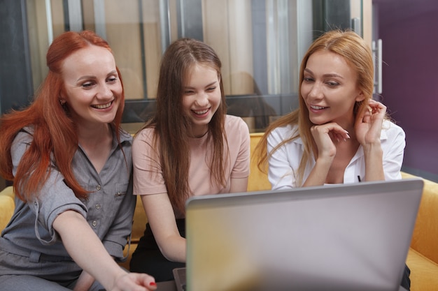 Equipo de negocios usando una computadora portátil durante su reunión en el espacio de trabajo moderno