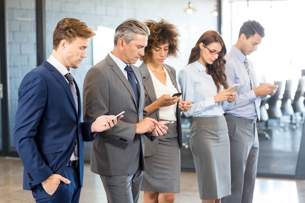 Equipo de negocios usando su teléfono móvil en la oficina.