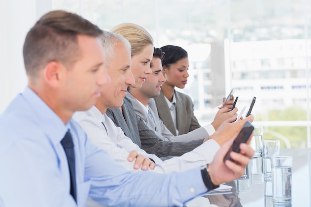 Equipo de negocios utilizando su teléfono móvil.