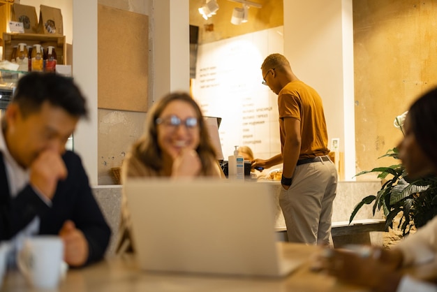 Equipo de negocios viendo algo en la computadora portátil en el café