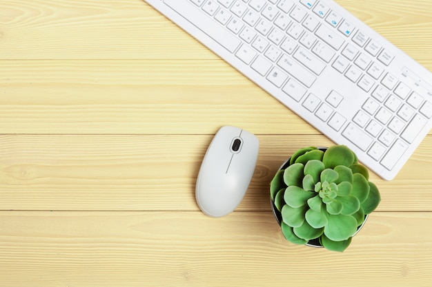 Equipo de oficina como teclado de computadora y otros suministros en mesa de madera