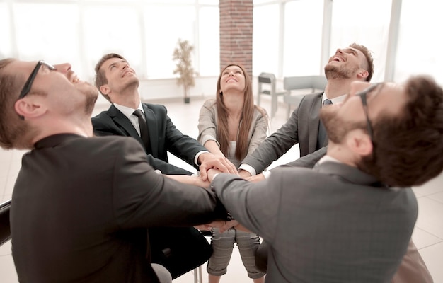 Equipo de personas con ideas afines sentadas en el escritorio y mirando hacia arriba