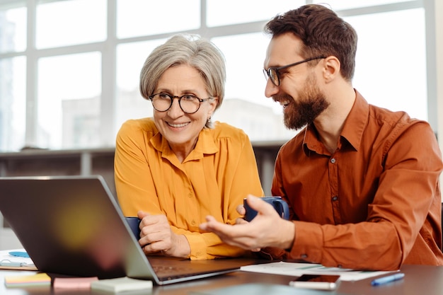 Equipo de personas de negocios sonrientes usando portátiles hablando planeando una startup trabajando en la oficina Trabajo en equipo