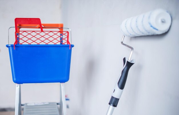 Foto equipo de pintura de la habitación cubo de pintura escalera y rodillo