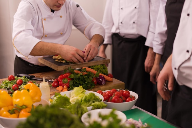 Equipo profesional de cocineros y chefs que preparan la comida en la concurrida cocina de un hotel o restaurante