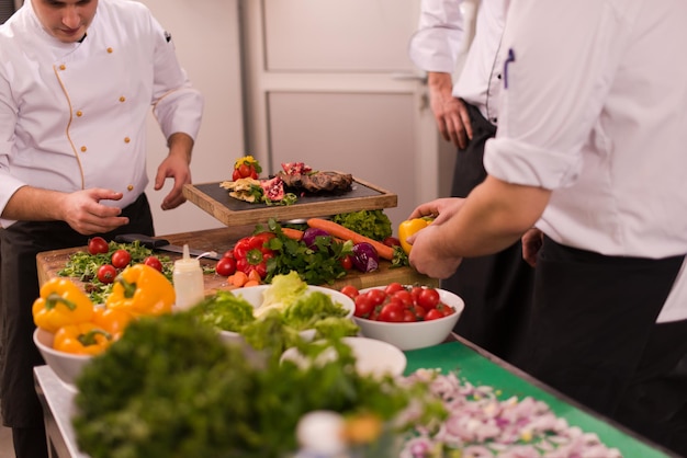 Equipo profesional de cocineros y chefs que preparan la comida en la concurrida cocina de un hotel o restaurante