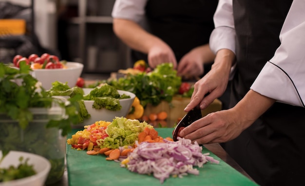 Equipo profesional de cocineros y chefs que preparan la comida en la concurrida cocina de un hotel o restaurante