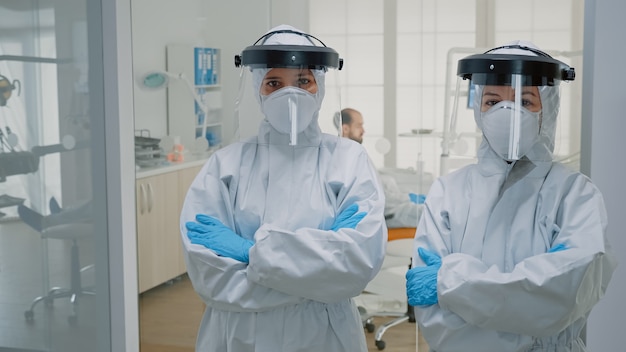 Equipo profesional de dentistas en trajes de ppe de pie