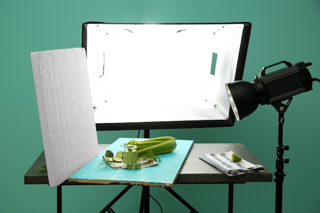 Equipo profesional y jugo de vegetales en estudio fotográfico Concepto de fotografía de alimentos