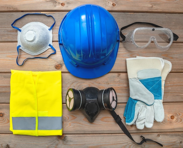 Equipo de protección de seguridad en el trabajo plano sobre fondo de madera