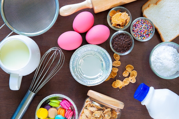 Foto equipo de repostería y repostería tazones con los ingredientes necesarios para hornear cupcakes coloridos.