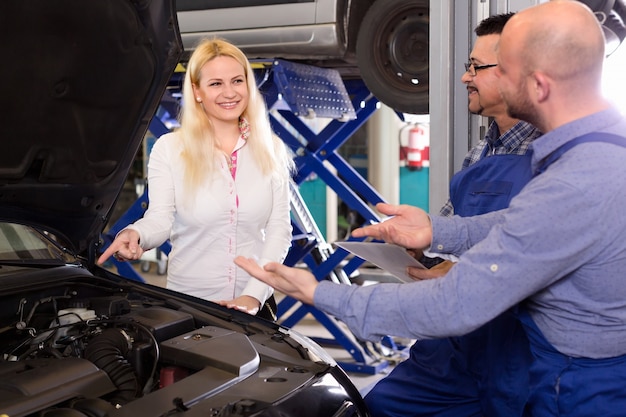 Equipo de servicio y conductor cerca del coche