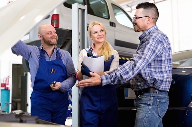 Equipo de servicio y conductor cerca del coche