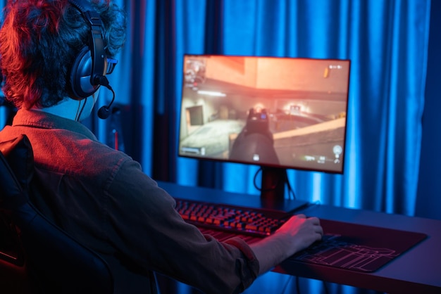 Equipo de streamer de juegos jugando al juego de batalla disparando en el gusher de imagen del lado trasero