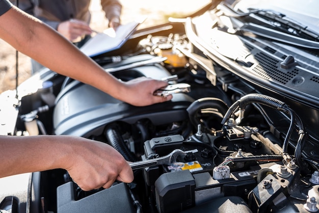 Equipo de técnicos trabajando de mecánico de automóviles en el servicio de reparación de automóviles y trabajador de mantenimiento que repara el vehículo con llave, servicio y mantenimiento del automóvil.