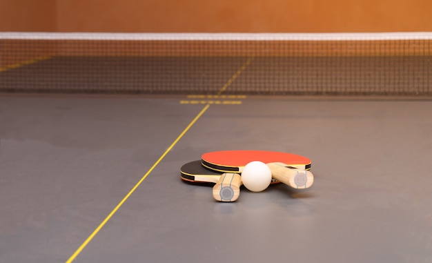 Equipo para tenis de mesa: raquetas, pelota, mesa, red.