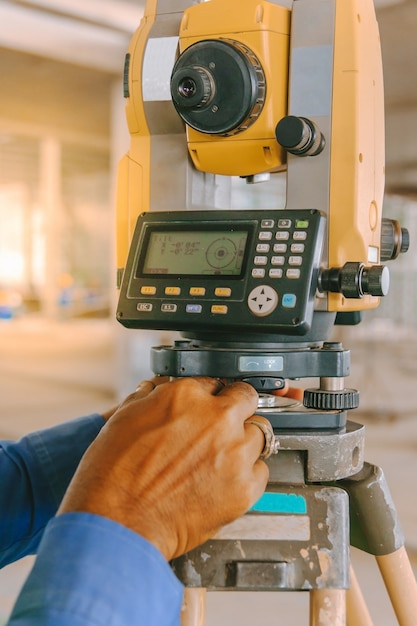 Equipo de topógrafo taquimétrico o teodolito al aire libre en el sitio de construcción