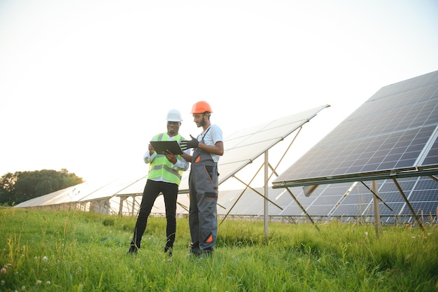 Un equipo de trabajadores multirraciales en un campo de paneles solares