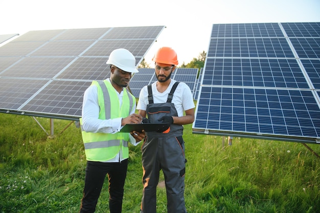 Un equipo de trabajadores multirraciales en un campo de paneles solares