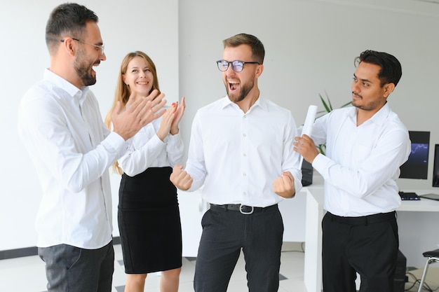 Equipo en el trabajo Grupo de jóvenes empresarios con ropa informal elegante trabajando juntos en una oficina creativa