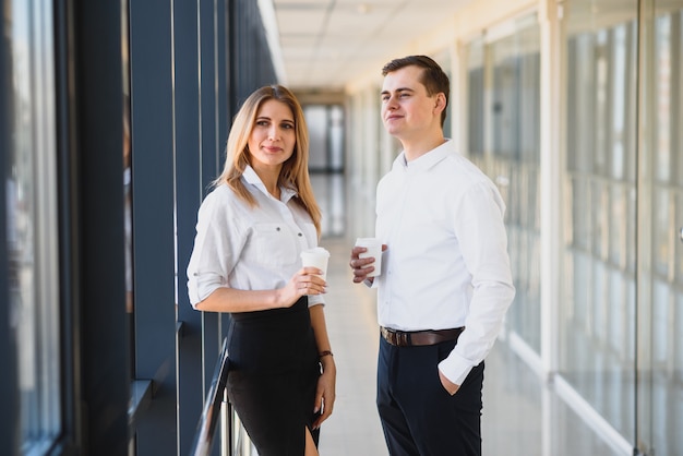 Equipo de trabajo sonriente durante el tiempo de descanso en la oficina brillante