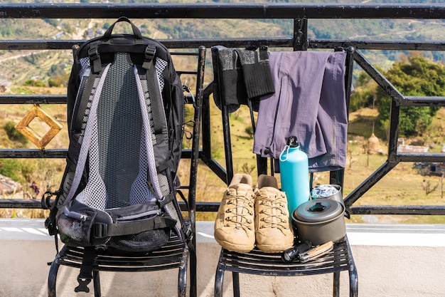 Equipo de trekking o senderismo: mochila, botas, calcetines, pantalones, navaja, frasco de agua, hervidor de agua y linterna. Concepto de actividad al aire libre. Naturaleza muerta foto de stock de cerca.