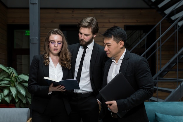 Un equipo de tres empleados discutiendo un proyecto.