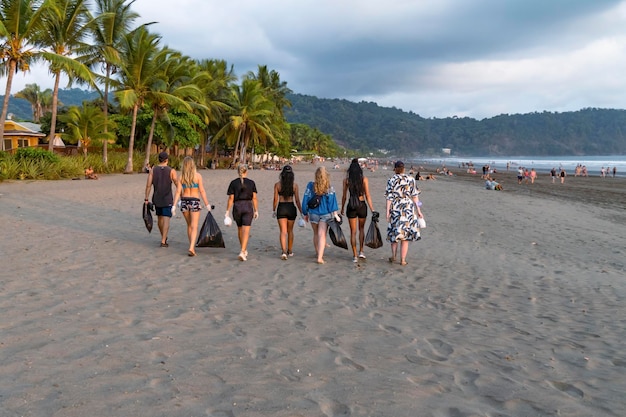 Equipo de vigorosos voluntarios de reciclaje recogiendo basura plástica en bolsas Salvemos el planeta