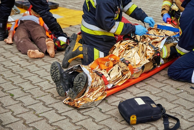 Los equipos de rescate brindan primeros auxilios a la víctima durante un accidente automovilístico. La persona lesionada en el accidente es lyi.