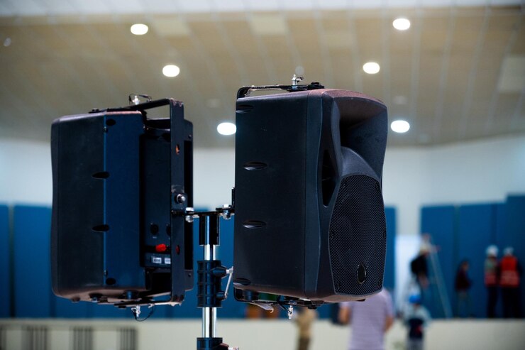 Equipos de sonido altavoces en una sala de conferencias personas irreconocibles trabajando en el fondo