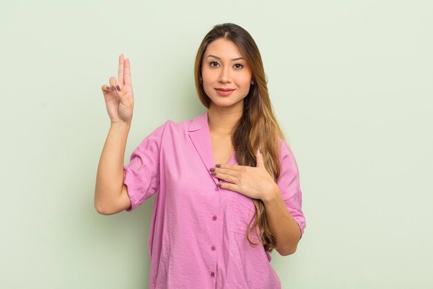 Er sieht glücklich, zuversichtlich und vertrauenswürdig aus, lächelt und zeigt ein Siegeszeichen mit einer positiven Einstellung