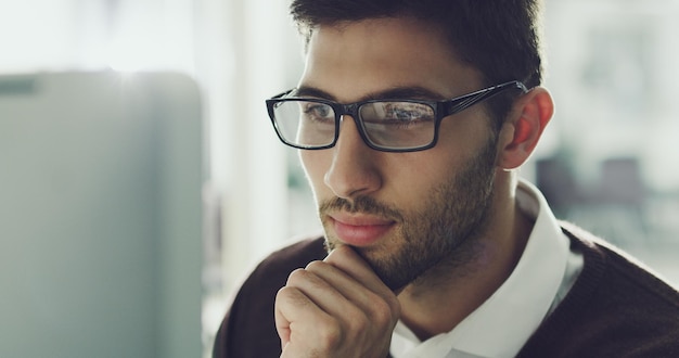 Er steckt voller brillanter Ideen Schnappschuss eines hübschen jungen Geschäftsmanns, der im Büro an seinem Computer arbeitet