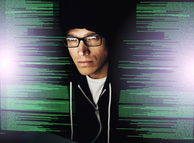Foto er wird der unknackbare hacker genannt, weil er die unknackbare kurzaufnahme eines jungen hackers knackt, der im dunkeln einen computercode knackt