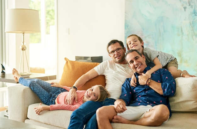 Eran una familia feliz Retrato recortado de una familia cariñosa de cuatro en el sofá de casa