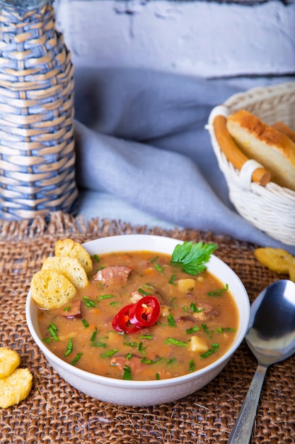 Erbsensuppe mit Fleisch, geräucherter Wurst und Croutons.