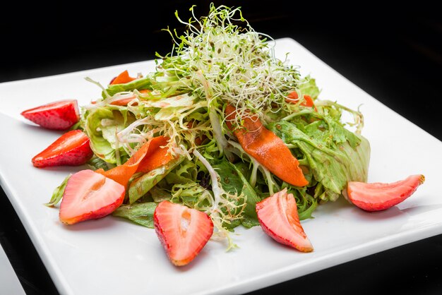 Erdbeer-avocado-salat mit cashewnüssen auf teller