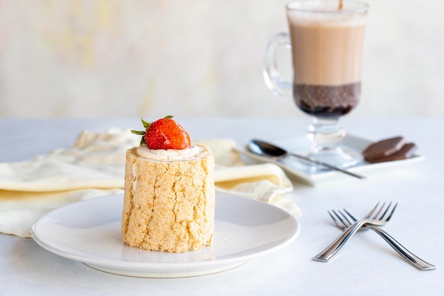 Erdbeer-Log-Kuchen auf weißem Hintergrund Mit heißer Schokolade auf der Seite hautnah